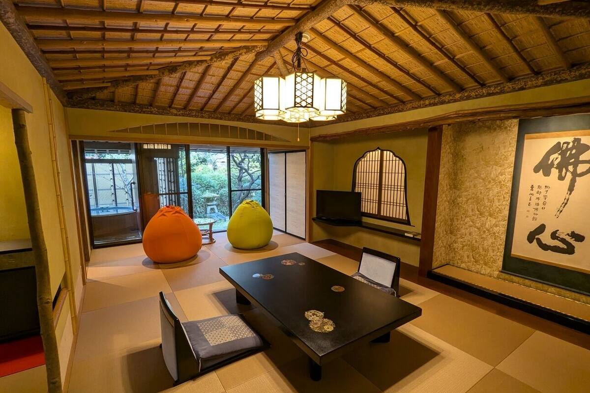 Une pièce de style japonais traditionnel, avec un sol recouvert de tatamis, une petite table basse avec des coussins, une lanterne suspendue et une porte coulissante en papier de riz (shoji).