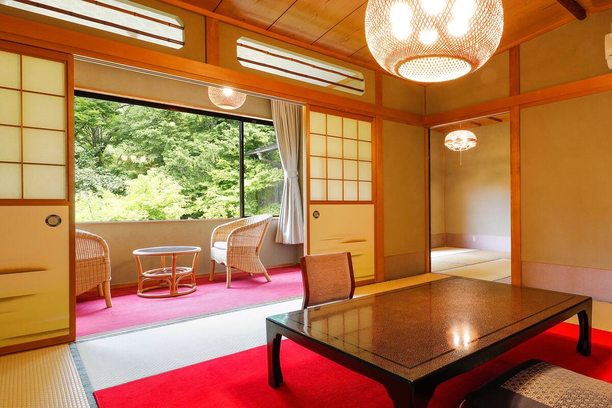 Une pièce de style japonais traditionnel, avec un sol recouvert de tatamis, une table basse et des portes coulissantes.