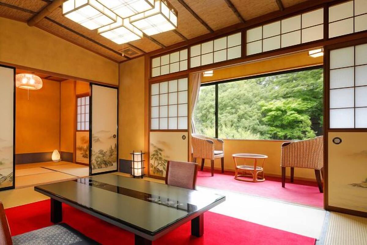 Une pièce de style japonais traditionnel, avec un sol recouvert de tatamis, une table basse et des portes coulissantes.
