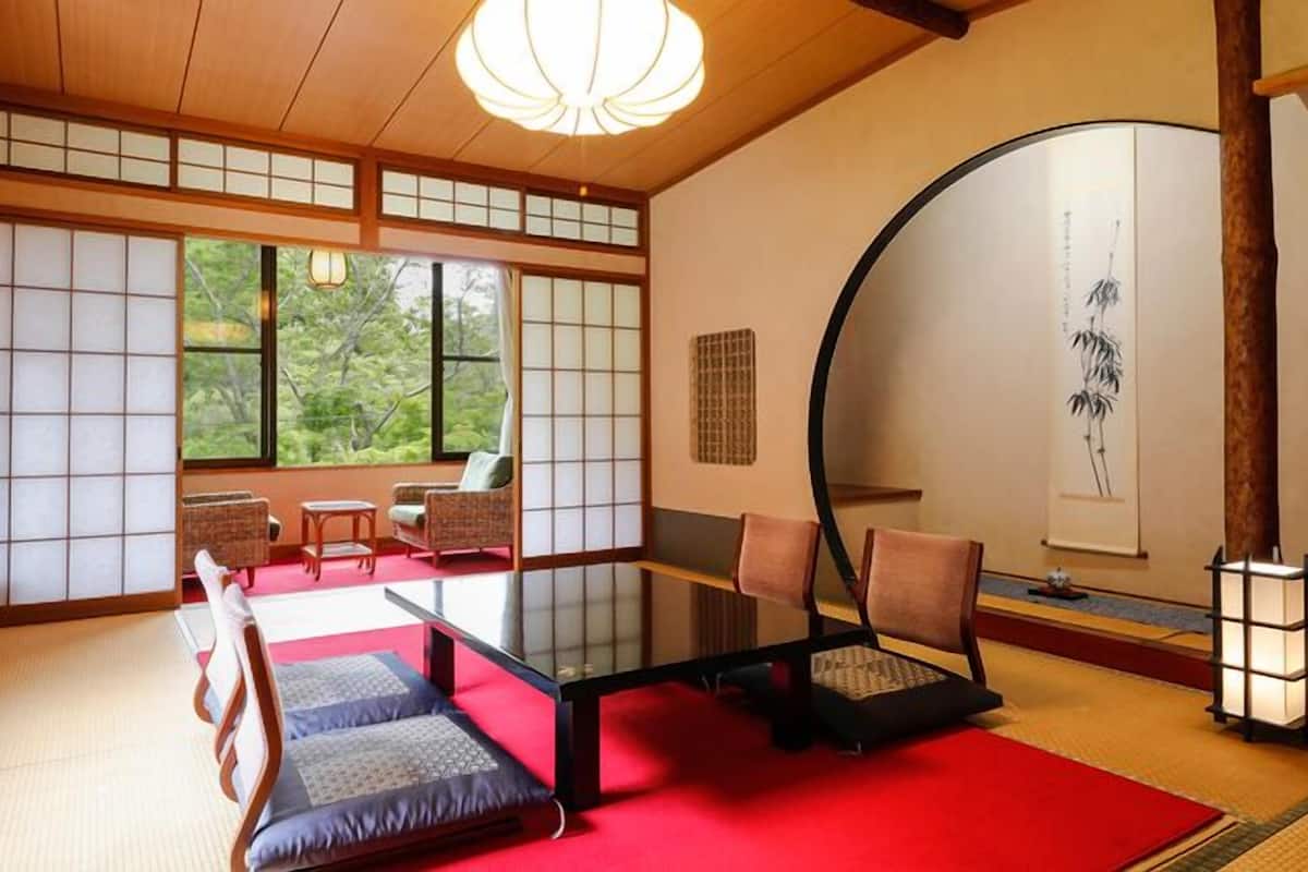 Une pièce de style japonais traditionnel, avec un sol recouvert de tatamis, une table basse et des portes coulissantes.