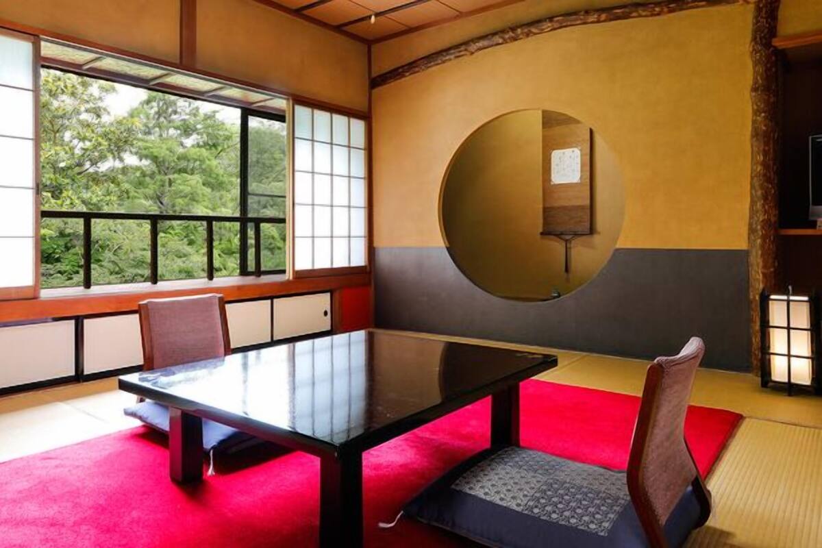 Une pièce de style japonais traditionnel, avec un sol recouvert de tatamis, une table basse et une fenêtre à panneaux coulissants (shoji).