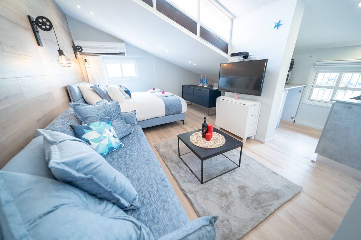 Comfort studio | Woonruimte | Een 65-inch flatscreentelevisie met satellietzenders en smart-tv