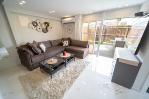 Signature Apartment | Living area | 65-inch flat-screen TV with satellite channels, Smart TV - Boutique and garden apartments in Hawaii complex by YalaRent - Families only (Eilat)