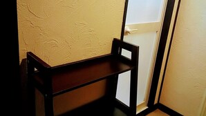 A room with a wooden bench, a thermostat on the wall, and a door with a frosted glass panel. - White Beachi inn Ishikawa (Uruma)