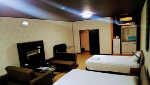 A hotel room with two beds, a sofa, a TV, and a kitchenette. - White Beachi inn Ishikawa (Uruma)