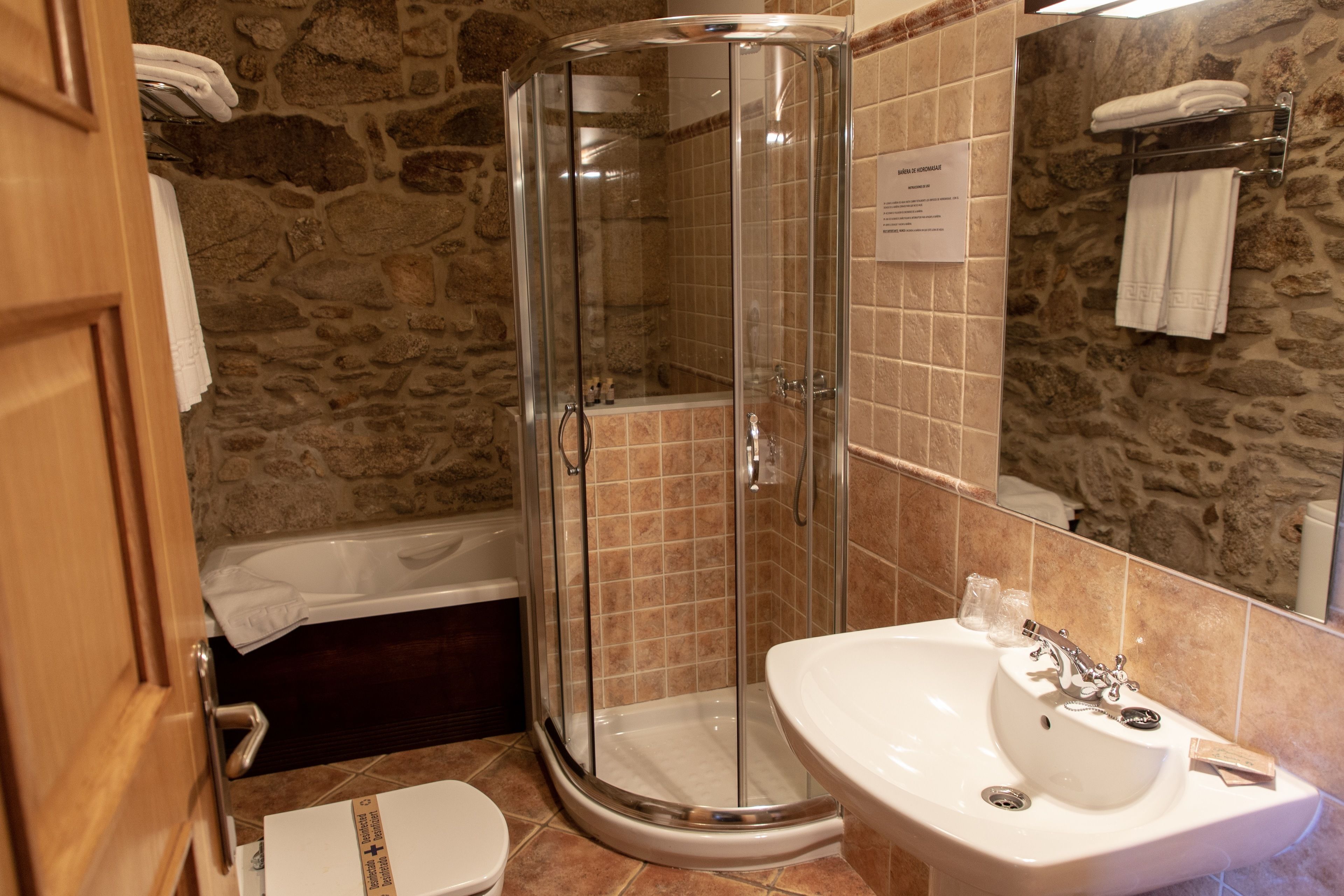 Une salle de bain avec une douche à parois de verre, un lavabo et une baignoire.