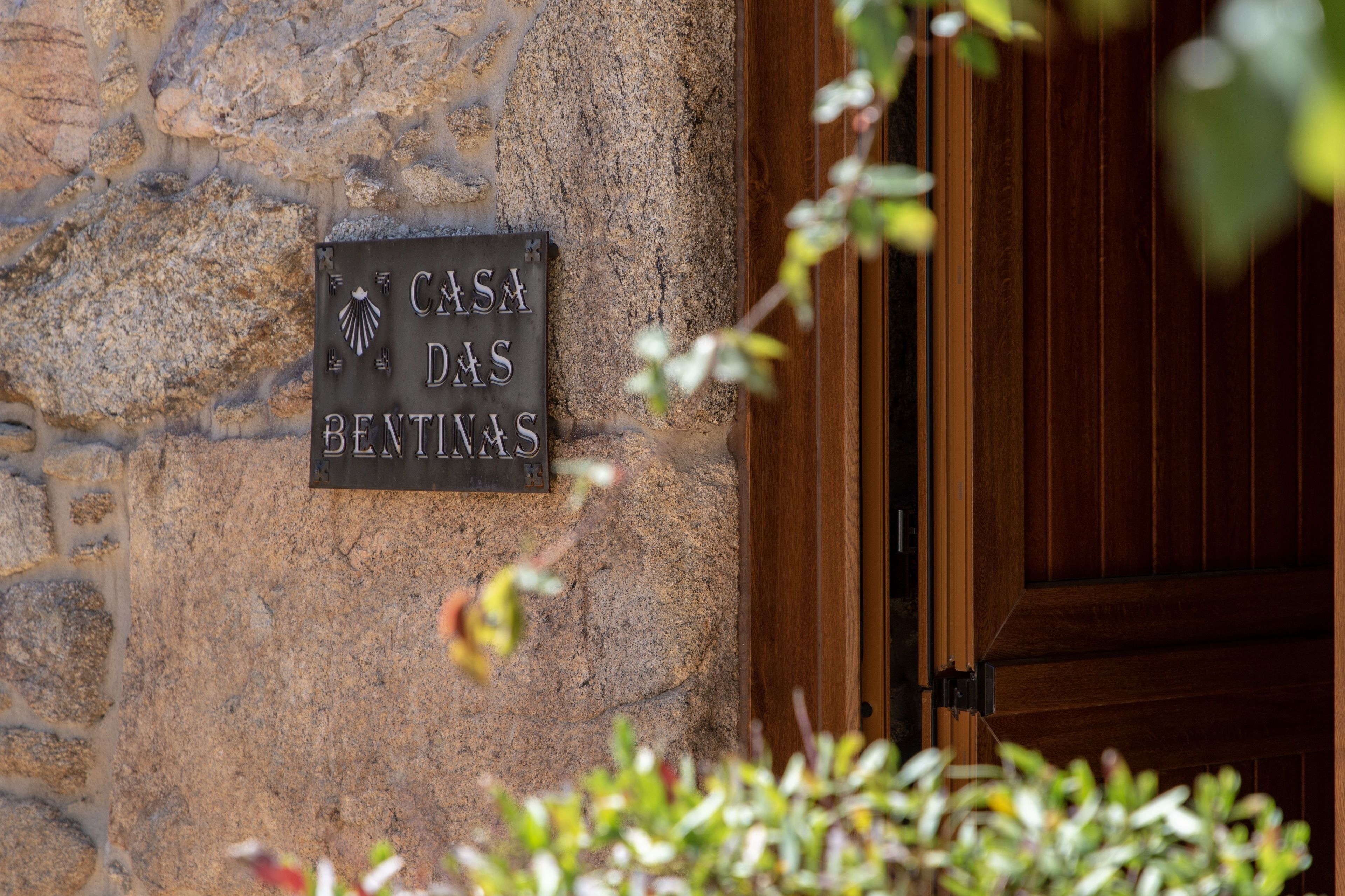 Un muro de piedra con un letrero que dice "CASA DAS BENTINAS".