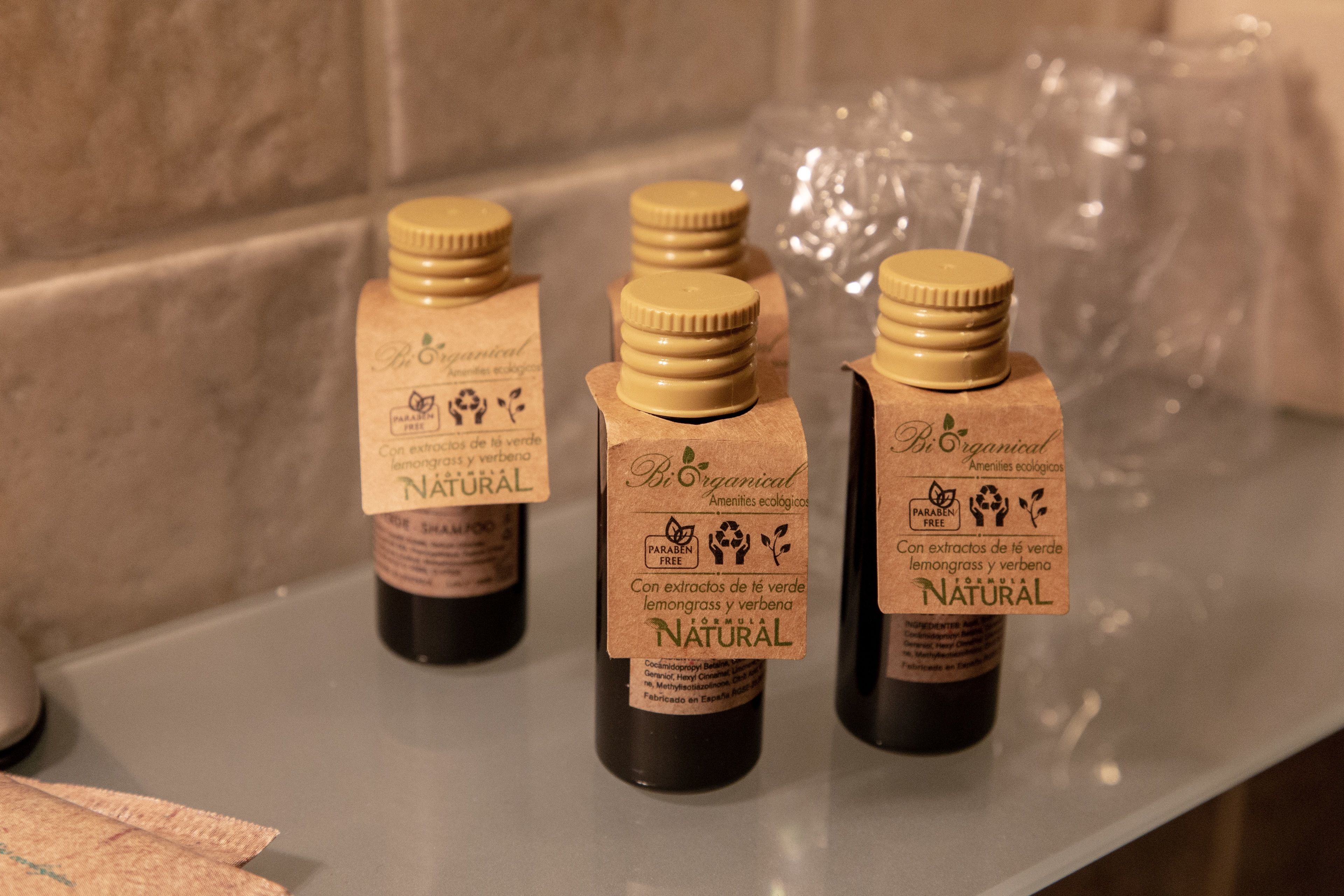 Three bottles of natural lemongrass and verbena extract on a countertop.