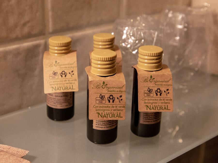 Three bottles of natural lemongrass and verbena extract on a countertop.