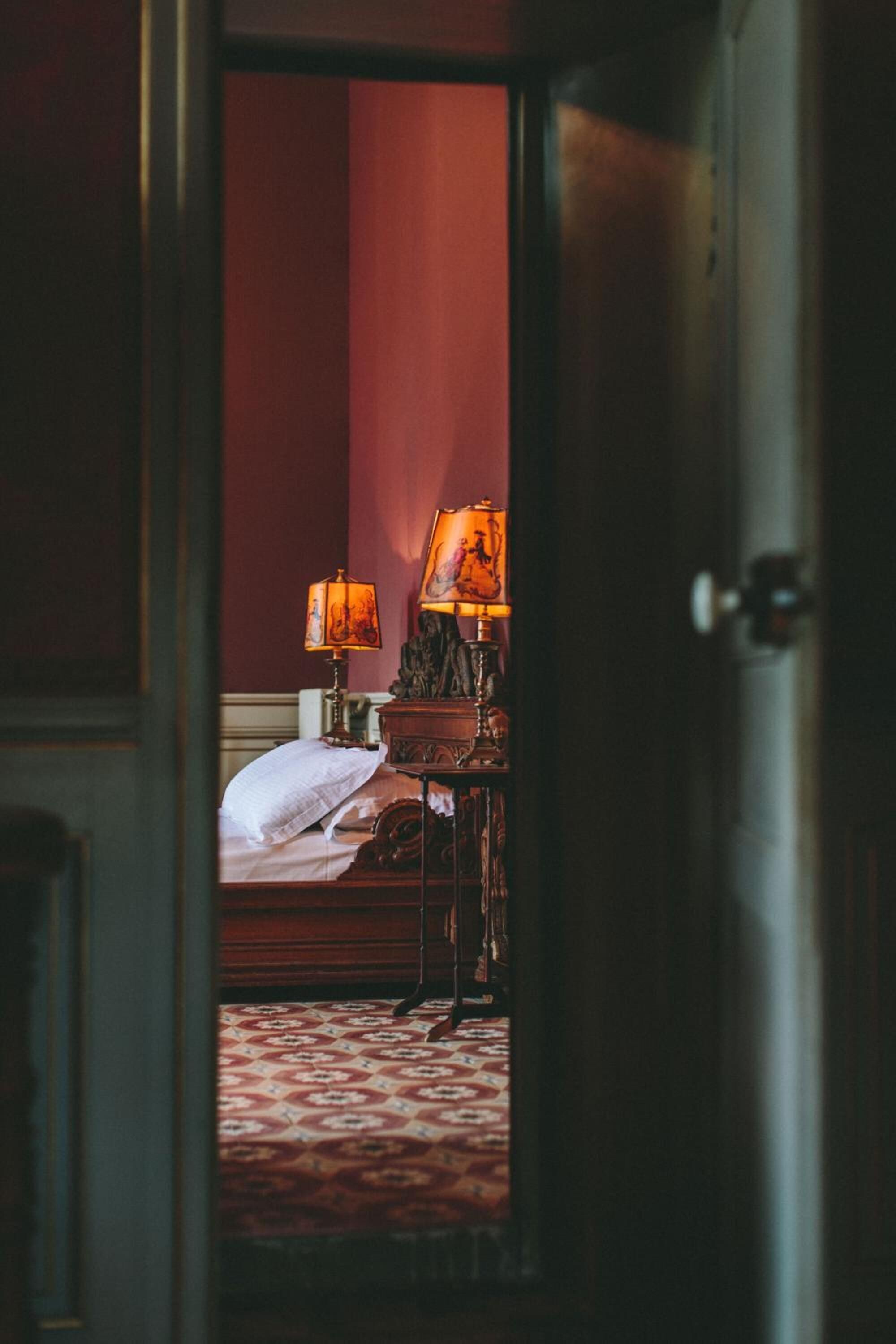 Una habitación de hotel con una cama, una mesita de noche y una lámpara.