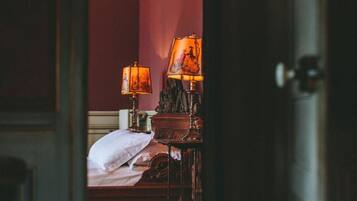 Una habitación de hotel con una cama, una mesita de noche y una lámpara.