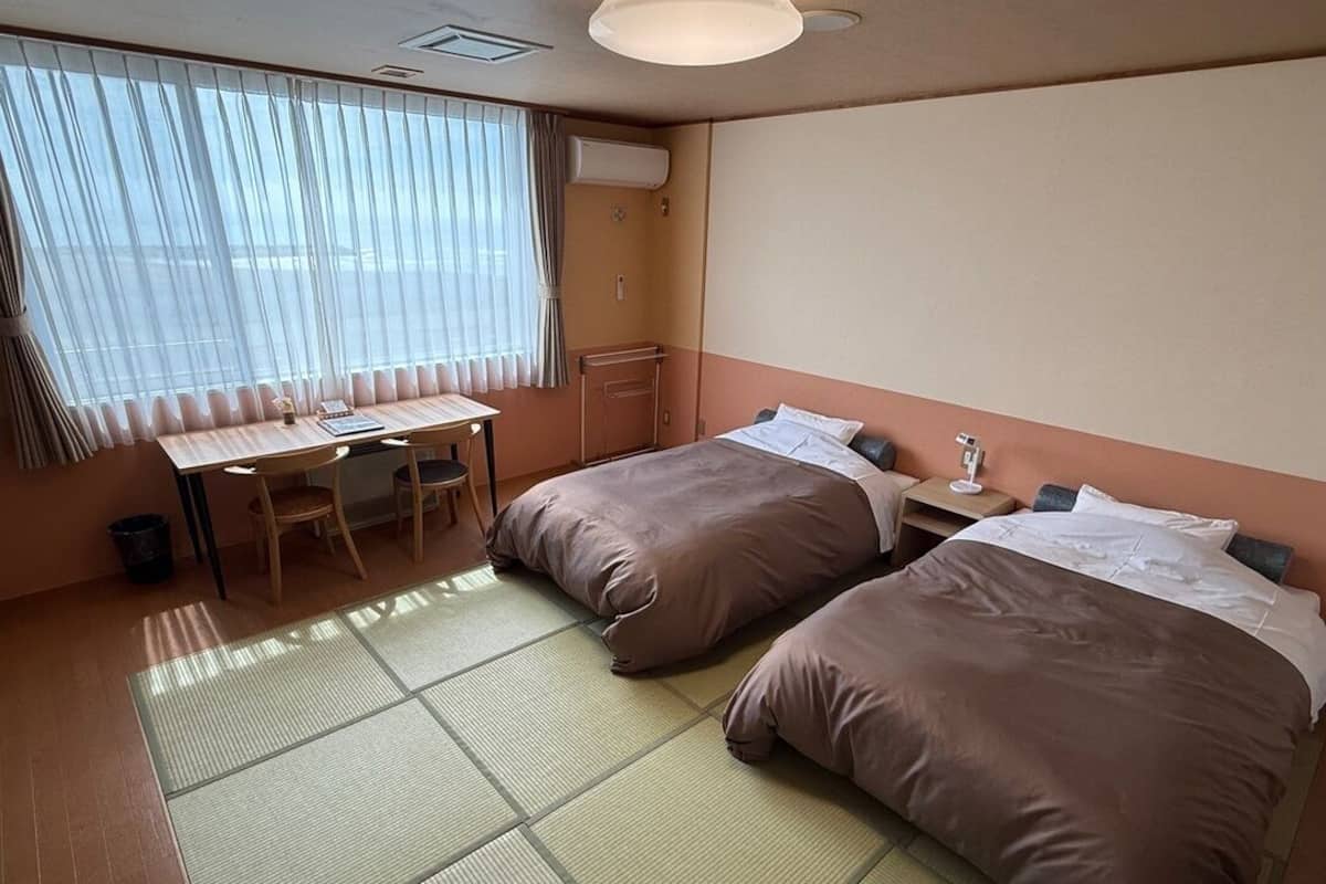Una habitación de hotel con dos camas, un escritorio y una silla.