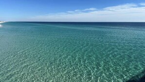 A clear view of a beach with shallow, turquoise waters and a distant shoreline. - 5 Pools, 2 heated indoor. 3 hot tubs, movie theater, Starbucks and bar and grill (Panama City Beach)