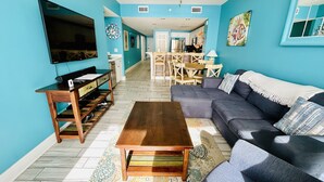 A living room with a sofa, coffee table, TV, and wooden furniture. - 5 Pools, 2 heated indoor. 3 hot tubs, movie theater, Starbucks and bar and grill (Panama City Beach)