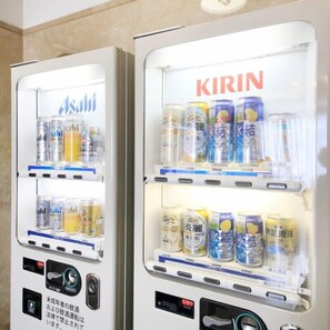 Two vending machines with drink options and a digital display.