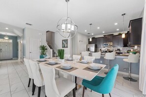A modern kitchen with dark cabinets, a stainless steel refrigerator, and a built-in oven.