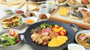Une variété de plats, dont un grand plateau garni de viandes, de légumes et d’œufs, entouré de petits bols contenant des condiments et des accompagnements.