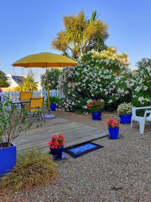 A wooden deck with outdoor furniture, a yellow umbrella, and potted plants. - "Chez Tante Na" Detached, renovated, bright family house. (Plouhinec)