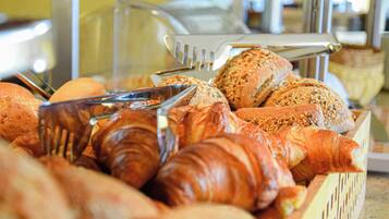 A variety of baked goods including bread and pastries in a basket.