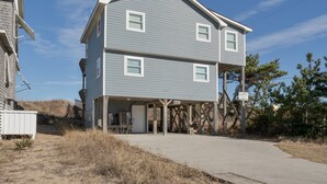 A two-story building with a flat roof, a covered front porch, and a visible entrance.
