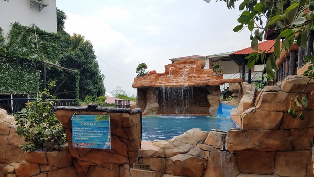 A pool area with a waterfall feature, surrounded by rock formations and a sign indicating it is 'Piscina N. 2'. - Hotel Club Quinta Pat Resort & Restaurant (San Antonio de Oriente)