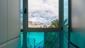 Ein Fenster mit Blick auf Gebäude und Palmen.