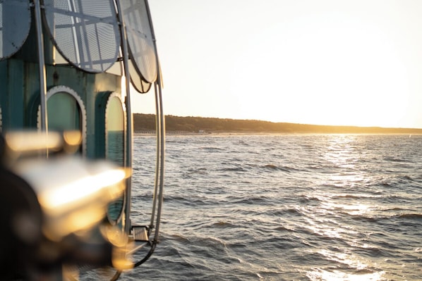 A view of the sea from a boat with a metal railing and circular windows. - Hotel Garni Kormoran (Zinnowitz)