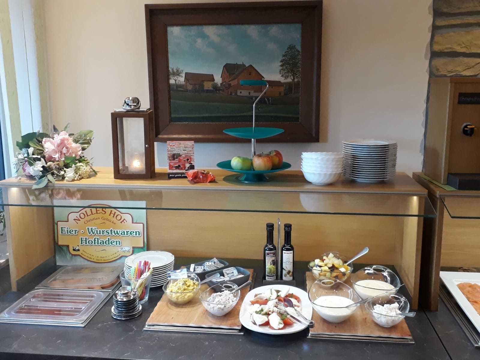 Un buffet proposant une variété de plats, d’assiettes et de condiments.