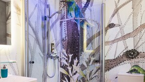 Een badkamer met een douchecabine van glas, een wit toilet en een wastafel met een houten blad.