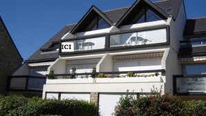 A modern two-story house with a balcony, large windows, and a garage door. - Duplex 5 people Carnac Beach with Feet (Carnac)