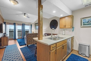 A compact kitchen with a central island, wooden cabinets, and a built-in dishwasher.