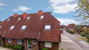 Un edifici residencial de dues plantes amb teulada inclinada, nombroses finestres i façana de maó.