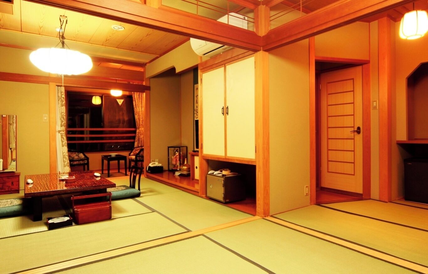 Ein traditioneller japanischer Raum mit Tatami-Boden, einem niedrigen Tisch und einer Schiebetür.