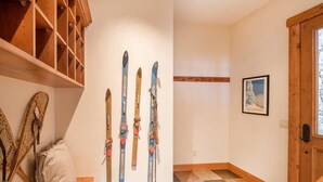 Ein Zimmer mit Holzbalken und einem Skiständer, der mehrere Ski beherbergt.