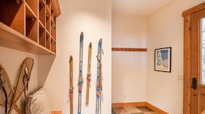 Une pièce avec des poutres en bois et un porte-skis contenant plusieurs paires de skis.