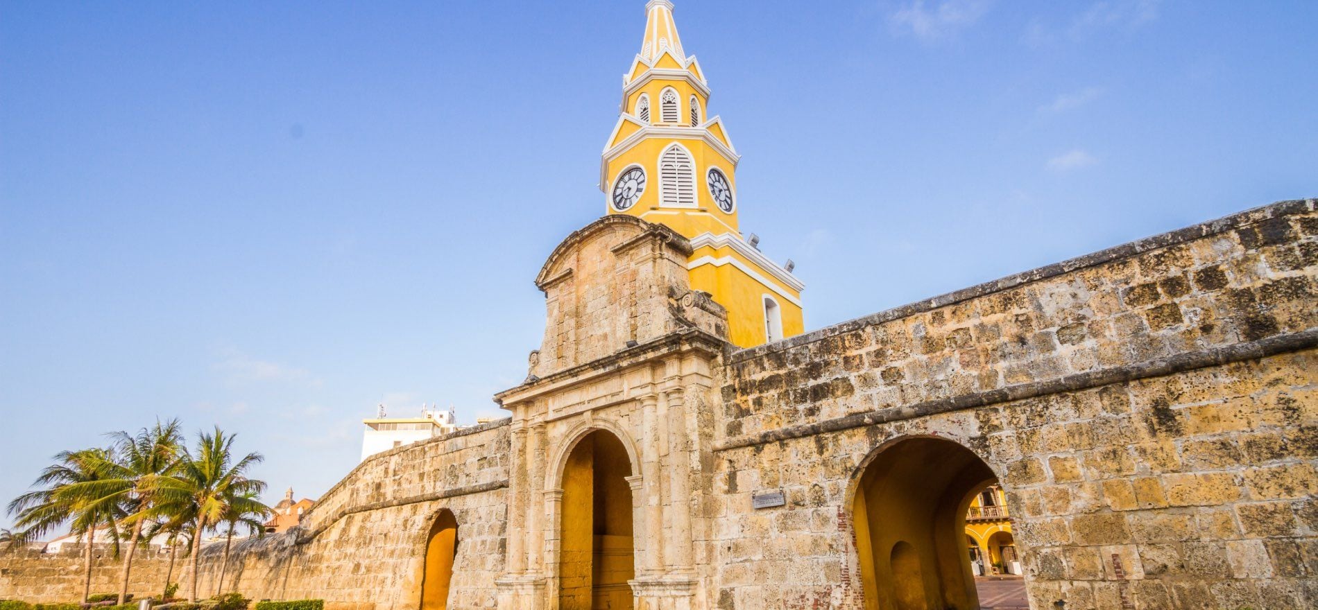 Un edificio histórico con una torre destacada y puertas en arco.
