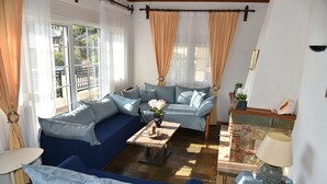 A living room with a blue sofa, a coffee table with a vase, and a fireplace with a lamp.