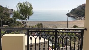 A balcony with a view of a beach and rocky coastline.