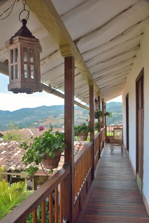 Un balcón de madera con vistas a un paisaje montañoso.