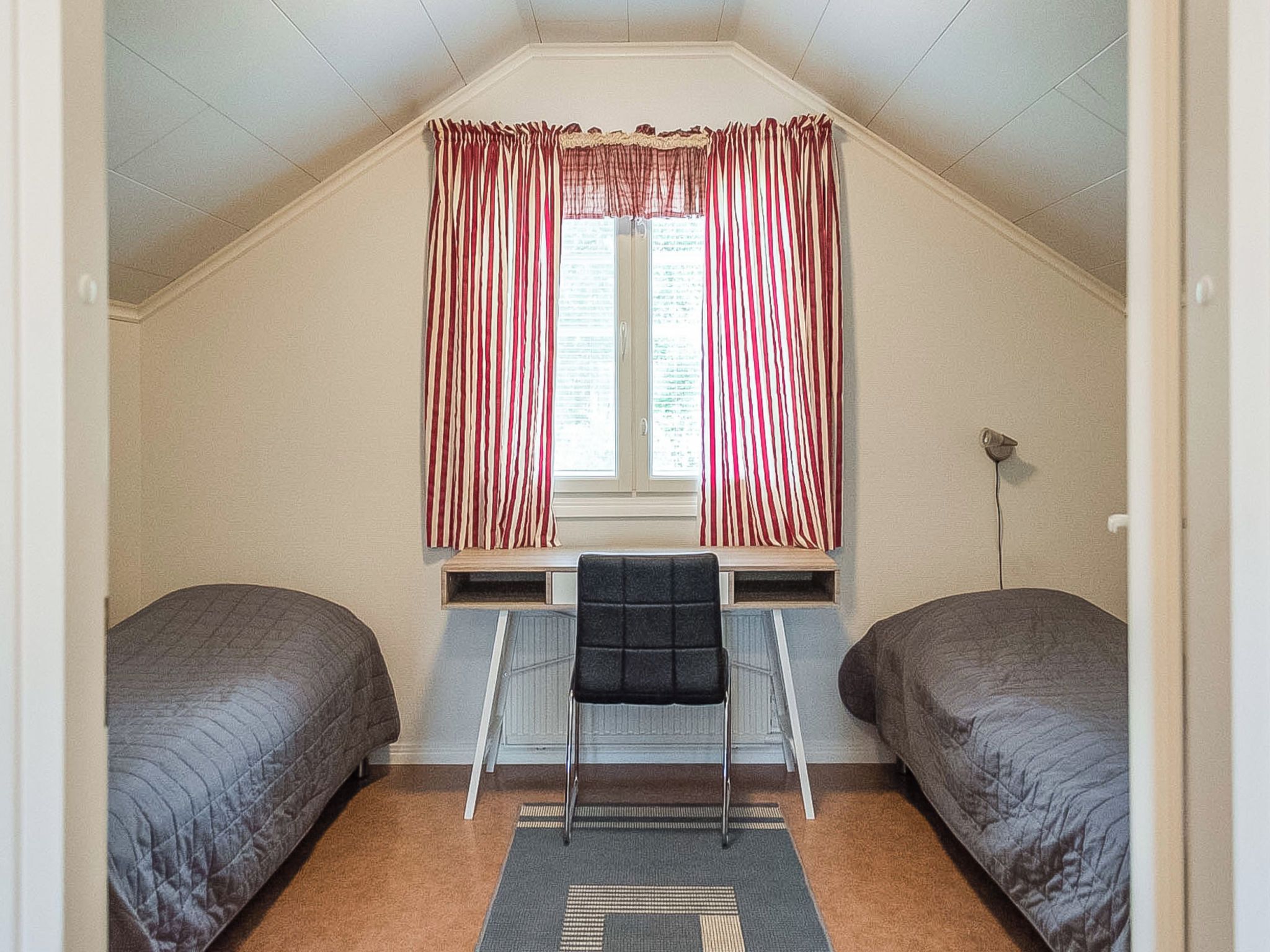 Une chambre de dortoir avec deux lits, un bureau et une chaise.