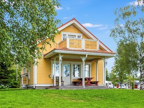 A yellow house with a balcony, a porch, and a red roof. - Hintrekki by Interhome (Kaustinen)