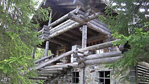 A log cabin with a stone foundation, wooden beams, and a staircase leading to the upper level. - Rantapuro by Interhome (Kuusamo)