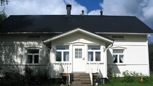 A two-story house with a dark roof, white exterior walls, and a front porch. - Rantala by Interhome (Kuusamo)
