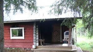 A rustic cabin with a wooden porch, a window, and a door. - Rantala by Interhome (Kuusamo)