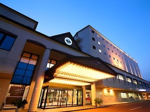 Um hotel com design moderno, apresentando uma grande entrada com marquise, diversas janelas e uma placa visível para 'The Platinum Suite'.
