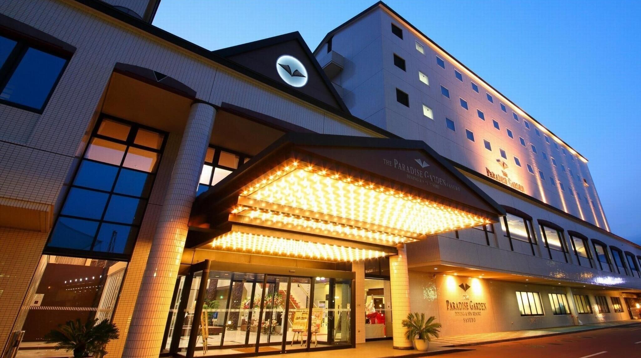 A hotel with a prominent entrance, a clock on the facade, and signage for 'Paradise Garden.'