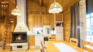 Un intérieur de chalet chaleureux avec une cheminée, des meubles en bois et un coin repas.