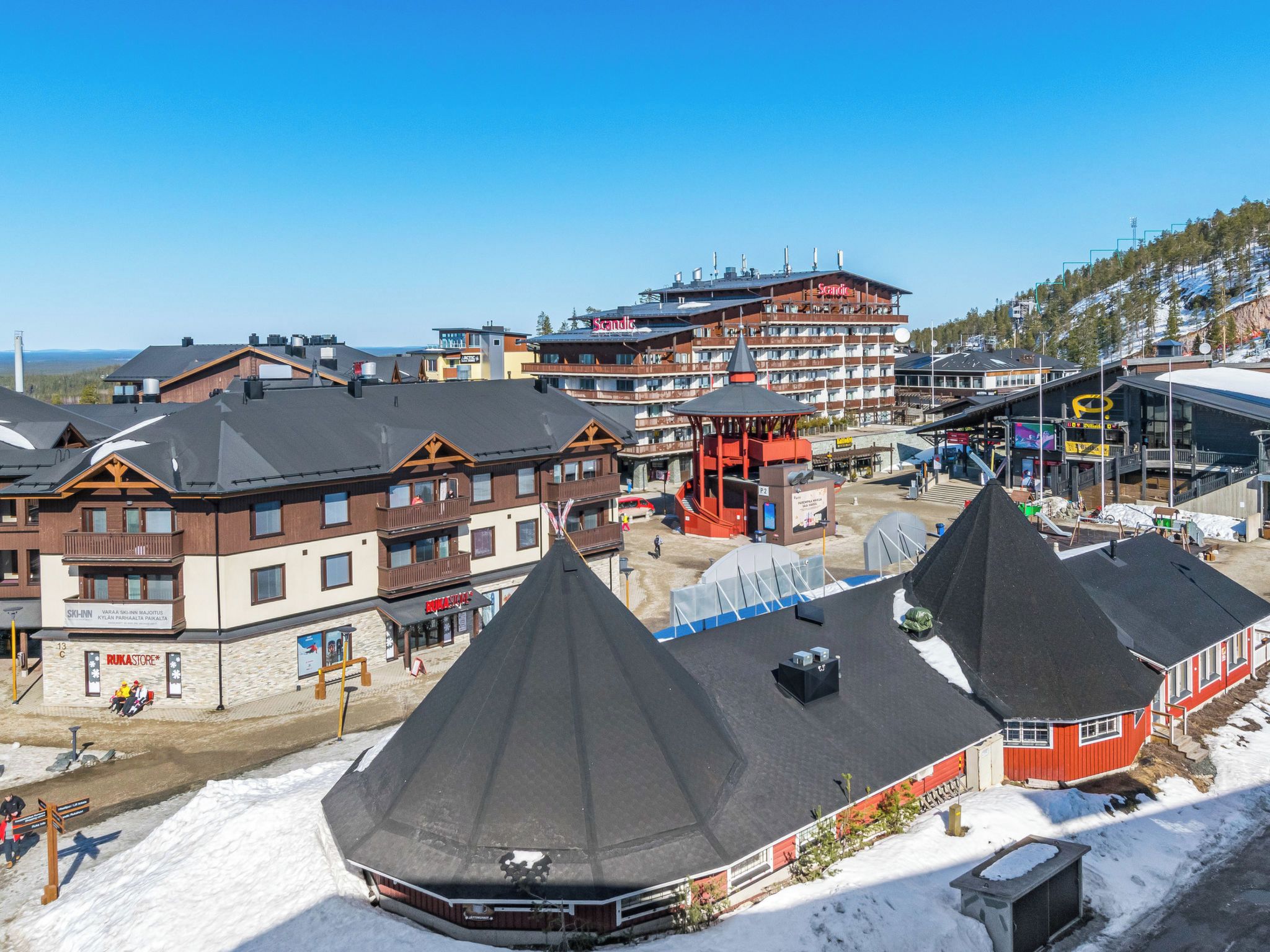A ski resort with multiple buildings, including a hotel with a ski lift and a restaurant.