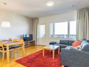 Un salon moderne avec un t éléviseur, un canapé et un coin repas.