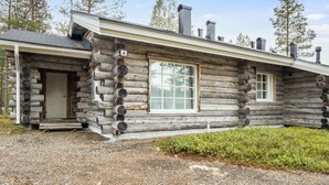 Eine Blockhütte mit Veranda, einer Tür und zwei Fenstern.